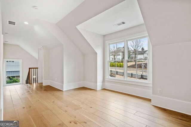 additional living space featuring light wood-style floors, visible vents, and baseboards