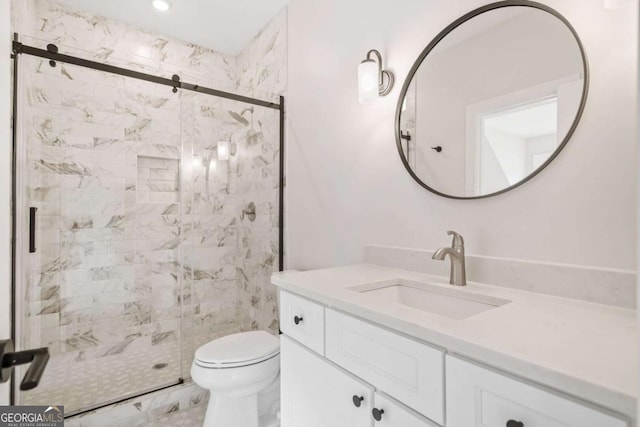 bathroom with toilet, vanity, and a shower stall