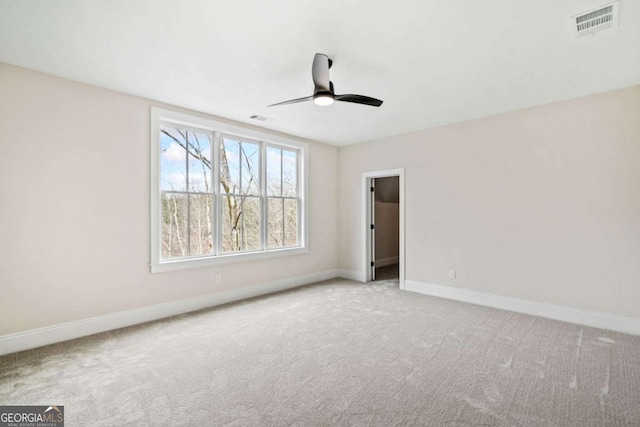 empty room featuring baseboards, visible vents, and carpet flooring