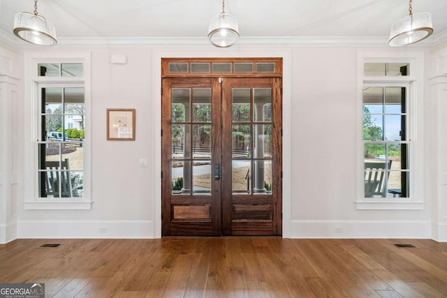 entryway featuring hardwood / wood-style floors, french doors, visible vents, and crown molding