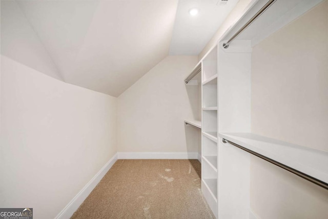 walk in closet featuring light carpet and vaulted ceiling