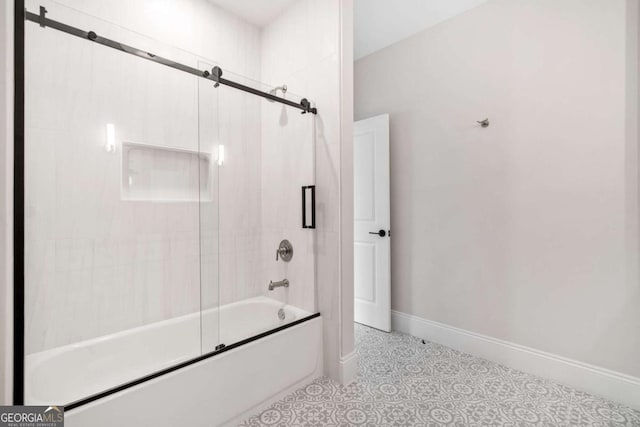 bathroom featuring shower / bath combination with glass door and baseboards