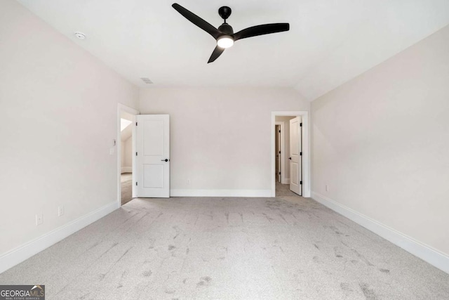 interior space with ceiling fan, carpet floors, lofted ceiling, and baseboards