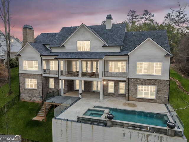 310 Timberview Trl, Alpharetta, GA 30004 - back of property at dusk featuring a patio area, a balcony, a chimney, a fenced backyard, and a yard
