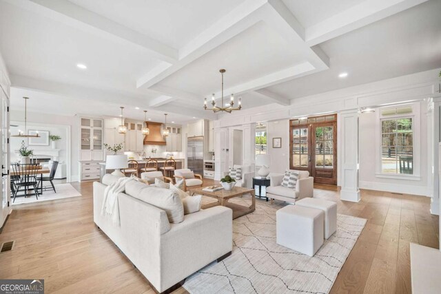 310 Timberview Trl, Alpharetta, GA 30004 - living room with beamed ceiling, light wood-type flooring, visible vents, and an inviting chandelier