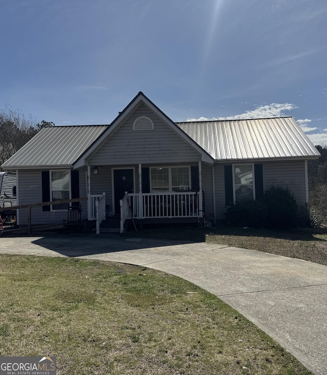 single story home featuring a porch, a front yard, and metal roof