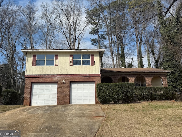 view of front of home featuring a garage, a front yard, brick siding, and driveway