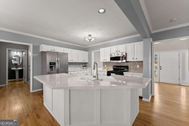 kitchen featuring white cabinets, tasteful backsplash, stainless steel appliances, and a sink