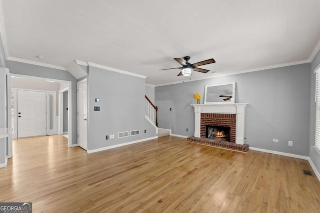 unfurnished living room with ceiling fan, light wood-style flooring, visible vents, baseboards, and stairs