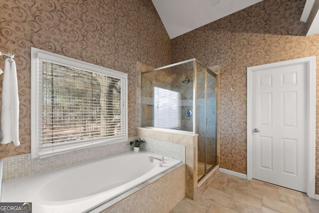 bathroom with vaulted ceiling, a shower stall, a bath, and wallpapered walls