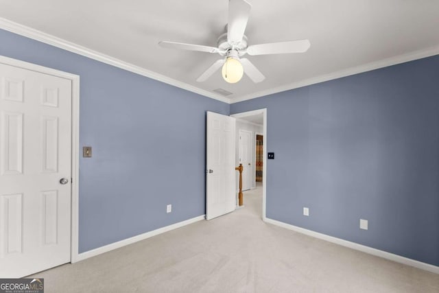 unfurnished bedroom featuring carpet floors, visible vents, baseboards, a ceiling fan, and crown molding