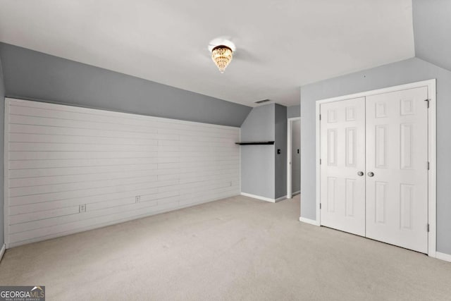 additional living space with carpet, visible vents, and vaulted ceiling