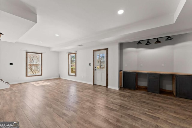 unfurnished living room with recessed lighting, baseboards, and wood finished floors