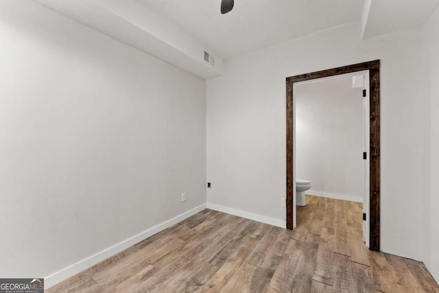 unfurnished room featuring baseboards, visible vents, and light wood finished floors