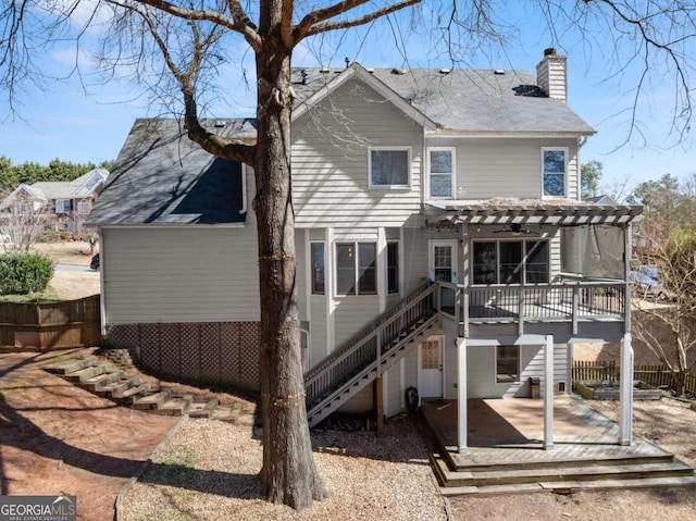 rear view of house featuring stairs, a deck, fence, and a pergola