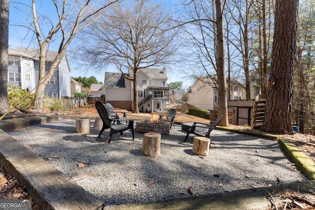 view of home's community featuring an outdoor fire pit, a patio, a residential view, stairs, and fence