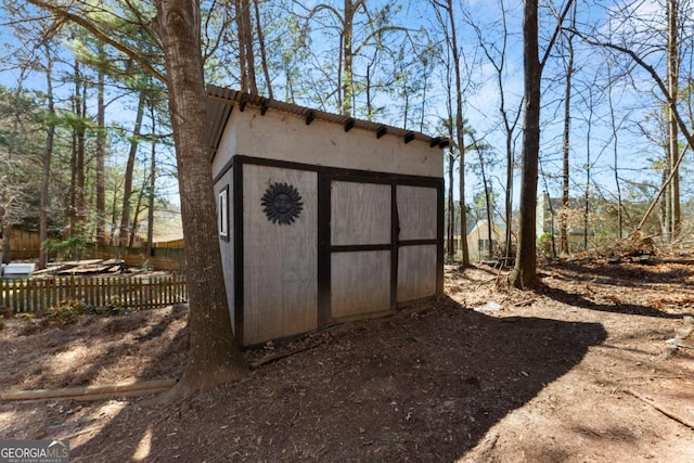 view of shed featuring fence