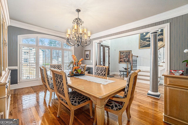 dining space with ornamental molding, light wood-style floors, an inviting chandelier, wallpapered walls, and baseboards