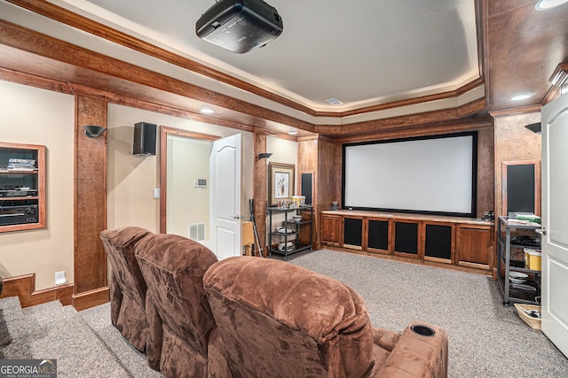 carpeted home theater room with crown molding, baseboards, and visible vents