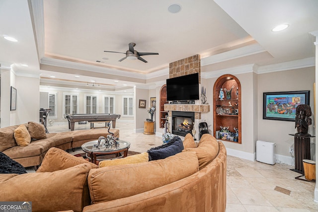 living room with a tray ceiling, a ceiling fan, ornamental molding, and pool table