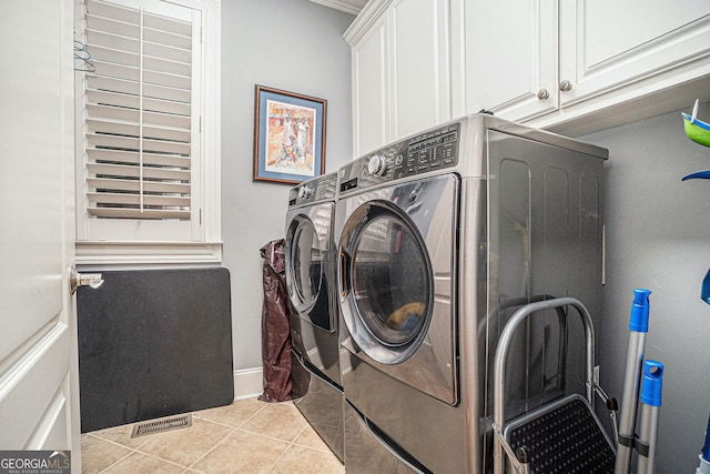 clothes washing area featuring light tile patterned floors, baseboards, visible vents, cabinet space, and washer and clothes dryer