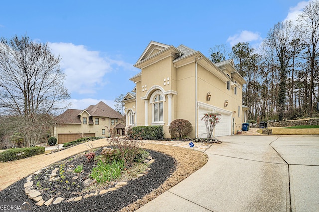 view of front facade with stucco siding, an attached garage, and concrete driveway