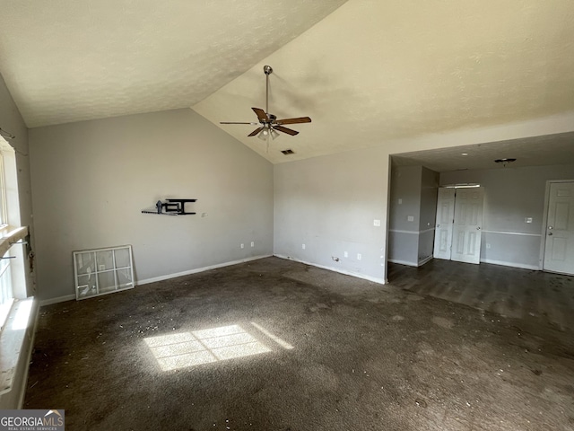 unfurnished room with ceiling fan, baseboards, vaulted ceiling, and a textured ceiling