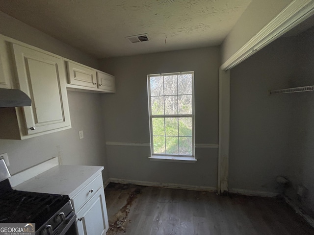 133 Dove Lndg, Social Circle, GA 30025 - kitchen with visible vents, white cabinets, a textured ceiling, wood finished floors, and gas range