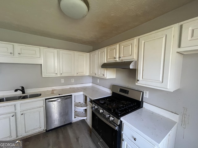 133 Dove Lndg, Social Circle, GA 30025 - kitchen featuring under cabinet range hood, stainless steel appliances, a sink, white cabinets, and dark wood finished floors