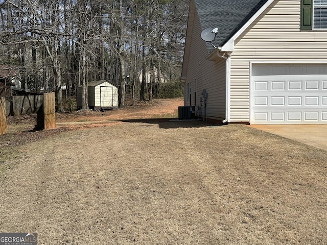 view of yard with a shed, fence, concrete driveway, and an outdoor structure