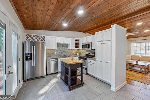 kitchen featuring a sink, white cabinetry, appliances with stainless steel finishes, decorative backsplash, and wooden counters