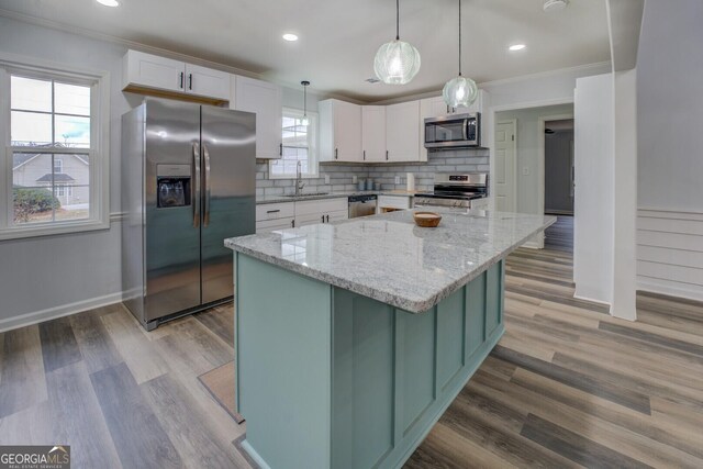 kitchen featuring appliances with stainless steel finishes, white cabinets, a sink, and tasteful backsplash