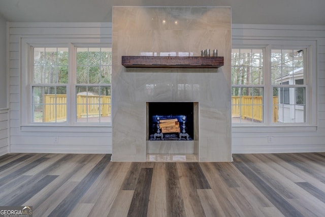 unfurnished living room featuring a fireplace, baseboards, and wood finished floors