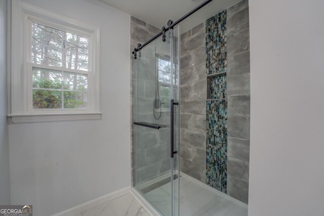 full bathroom with marble finish floor, a shower stall, and baseboards