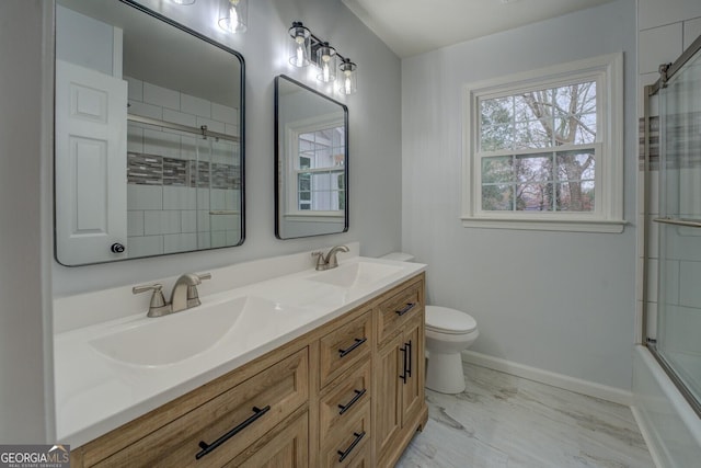 bathroom with marble finish floor, a sink, toilet, and baseboards