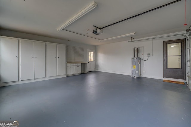 garage with baseboards, electric water heater, and a garage door opener