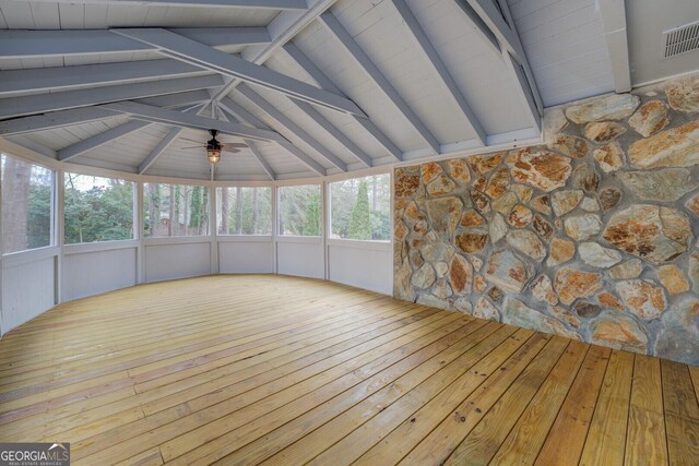 unfurnished sunroom featuring ceiling fan, lofted ceiling with beams, and visible vents