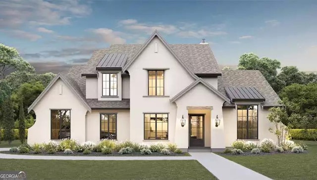 view of front of home featuring metal roof, roof with shingles, a standing seam roof, a front yard, and stucco siding