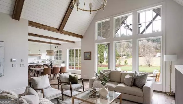 living room with high vaulted ceiling, a chandelier, beamed ceiling, and wood finished floors