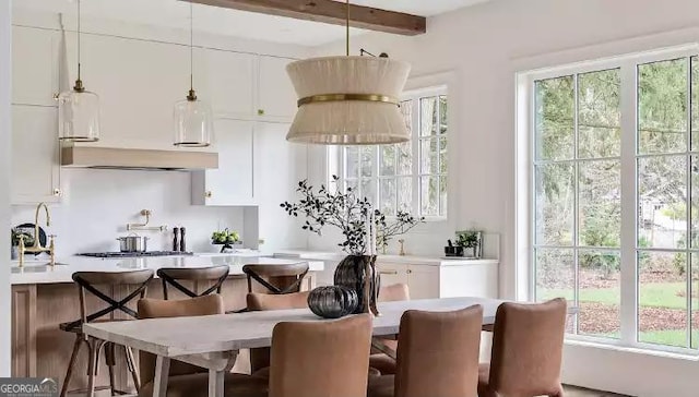 kitchen featuring hanging light fixtures, white cabinetry, light countertops, and a kitchen breakfast bar