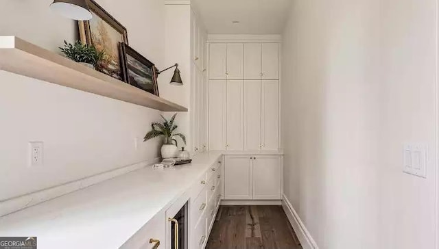 bar featuring dark wood finished floors and baseboards