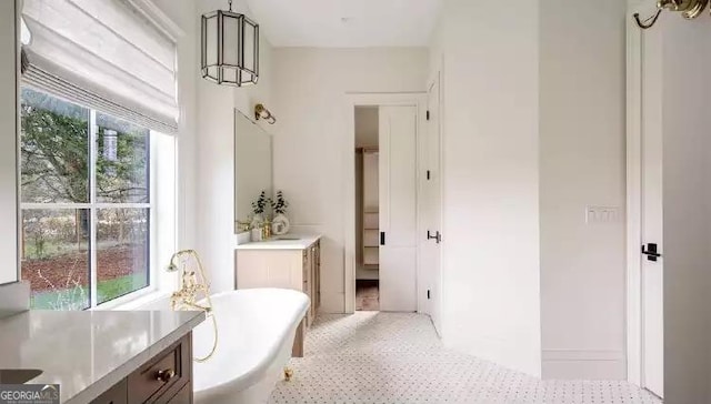 bathroom with a soaking tub, speckled floor, and vanity