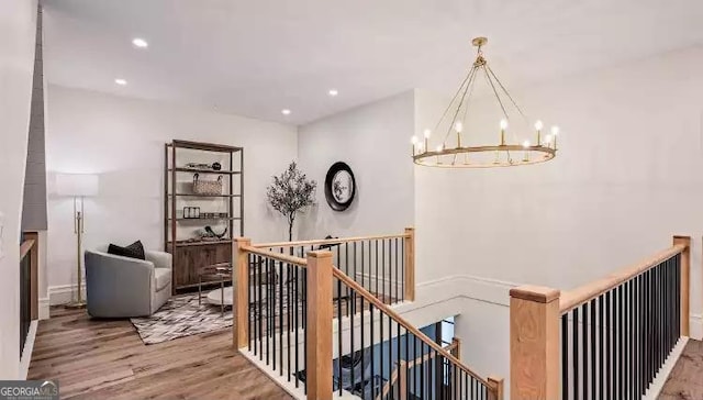 hall featuring a chandelier, recessed lighting, an upstairs landing, and wood finished floors