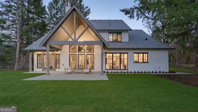 rear view of house featuring a patio area, stucco siding, french doors, and a yard