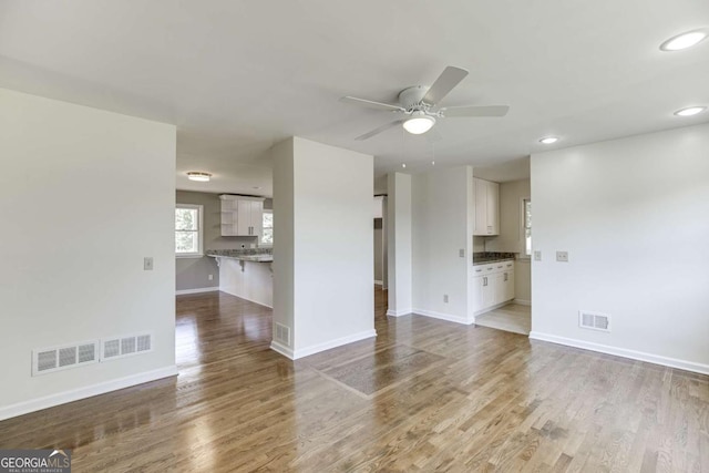 unfurnished living room featuring recessed lighting, visible vents, baseboards, and wood finished floors