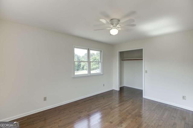 unfurnished bedroom featuring dark wood-style floors, a closet, a ceiling fan, and baseboards