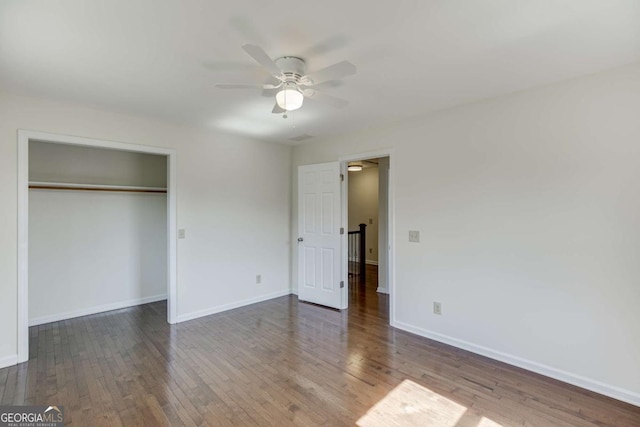 unfurnished bedroom with wood-type flooring, baseboards, and a closet