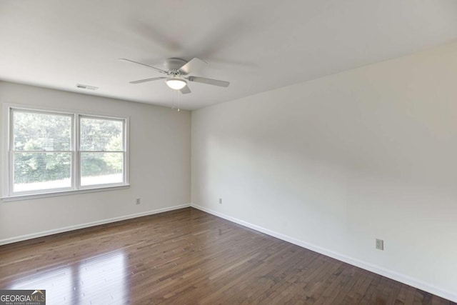 unfurnished room with visible vents, ceiling fan, baseboards, and wood finished floors