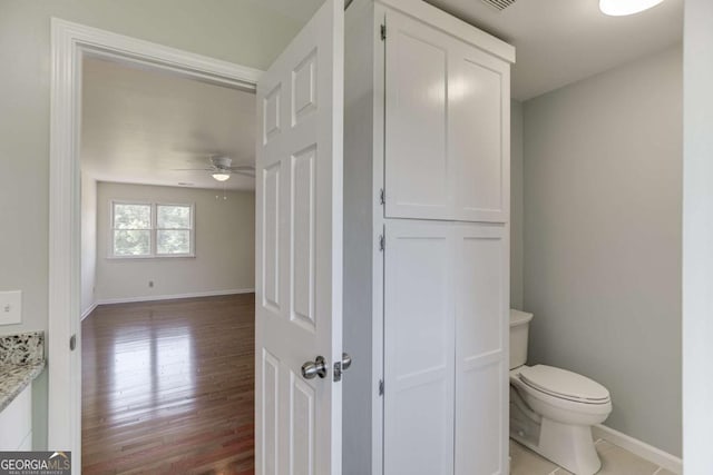 bathroom featuring ceiling fan, wood finished floors, toilet, and baseboards