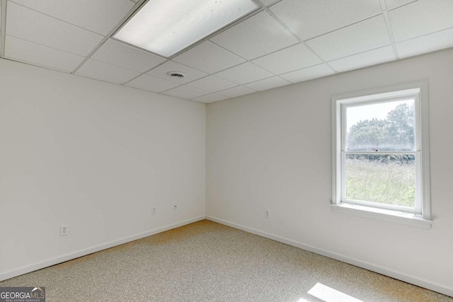 spare room featuring baseboards, visible vents, and a drop ceiling